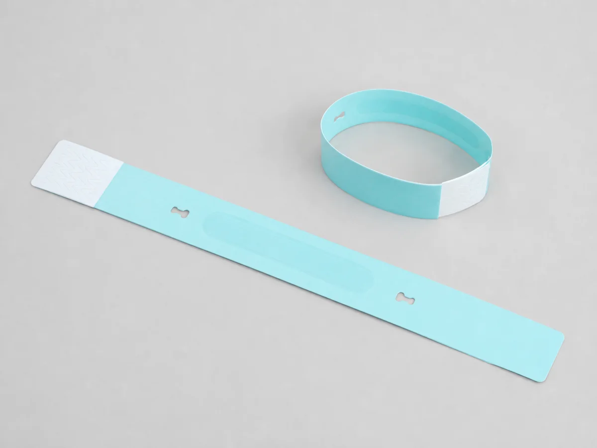Tear-resistant synthetic RFID wristband shown flat and closed with tamper cuts