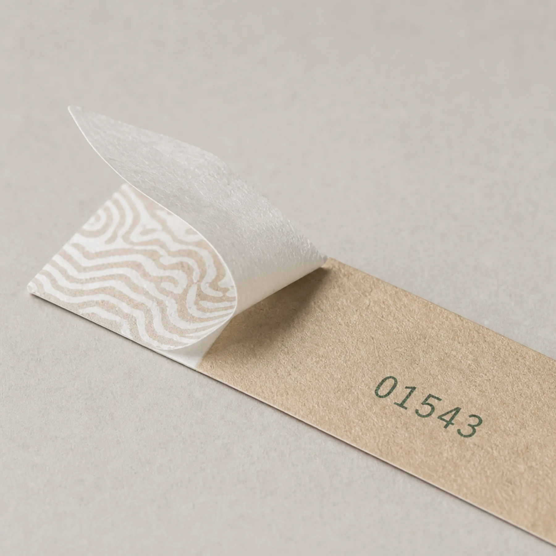 Close view of a numbered paper wristband and tamper-evident adhesive closure